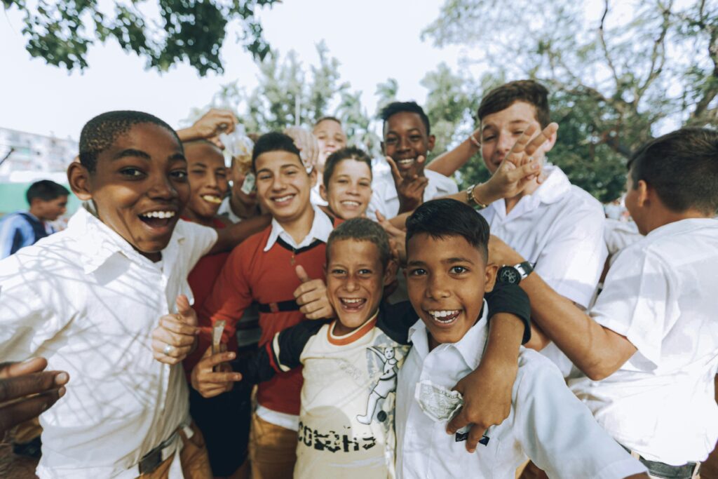 Current image: A group of smiling teenagers enjoying a sunny day outdoors, showcasing friendship and diversity.